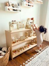Load image into Gallery viewer, Child playing with educational toys on a wooden shelf in a room with white walls and a rug.