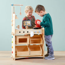 Load image into Gallery viewer, Two children playing with a wooden play kitchen set against a light blue wall.