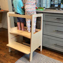 Load image into Gallery viewer, Children using a wooden step stool in a kitchen.
