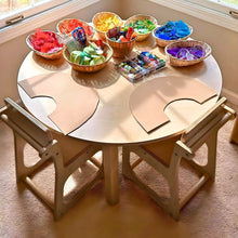 Load image into Gallery viewer, Children's play table with colorful art supplies and chairs in a room with a window.