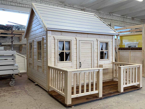 Kids outdoor playhouse in natural wood color with white roof and terrace with railing by Whole woodPlayhouses
