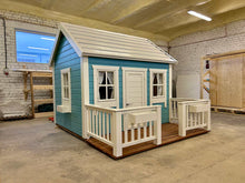 Load image into Gallery viewer, Children's playhouse with blue and white exterior in a warehouse by WholeWoodPlayhouses