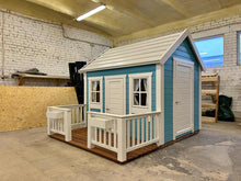 Load image into Gallery viewer, Small blue and white playhouse right side view in a workshop by WholeWoodPlayhouses