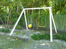 Load image into Gallery viewer, Kids swing in the yard by the bushes, white wooden frame, two yellow swings with a yellow metal chains, one for a teenager, one for a toddler by WholeWoodplayhouses
