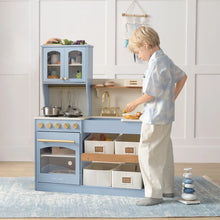 Load image into Gallery viewer, Child playing with a toy kitchen set in a room with light-colored walls.