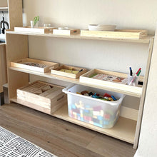 Load image into Gallery viewer, Wooden shelves with storage bins and toys on a wooden floor.