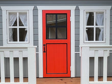 Load image into Gallery viewer, Red wooden door with black window panes on a gray playhouse by WholeWoodPlayhouses