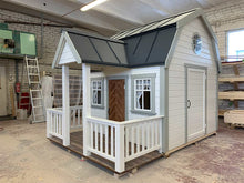 Load image into Gallery viewer, Outside of Kids Playhouse Grand Farmhouse Inside Of Workshop With Black Metal Roof And White Outdoor Siding And Gray Trims, Brown Fishbone Wooden Door And Gray Adult Door And Round Top Window, Terrace And White Railings by WholeWoodPlayhouses