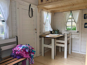 Inside view with kids furniture and curtains of Wooden Playhouse Snowy Owl by WholeWoodPlayhouses 
