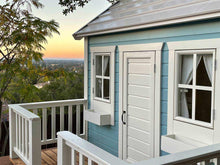 Load image into Gallery viewer, Wooden Playhouse Closeup of front door, windows with curtains and flower boxes with the sunset backround by WholeWoodPlayhouses