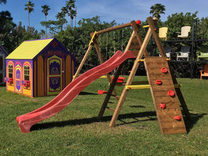 Kids outdoor playset on green grass with red slide, wooden climbing wall and swings by WholeWoodPlayhouses
