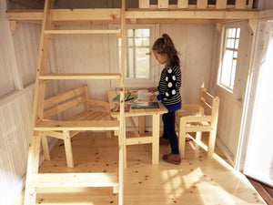 A kid playing inside of a Wooden Outdoor Playhouse Sunshine with a loft by WholeWoodPlayhouses