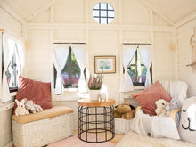 Load image into Gallery viewer, Inside view with toys, kids armchair, table and curtains  of black and white Wooden Playhouse Arctic Auk by WholeWoodPlayhouses