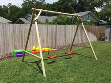 Load image into Gallery viewer, Mathias swing set with two swings for kids produced by WholeWoodPlayhouses on a sunny day on green grass in front of wooden fence