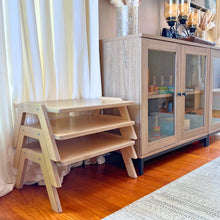 Load image into Gallery viewer, Wooden desks stacked in a room with a cabinet and curtains.
