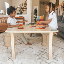 Load image into Gallery viewer, Two children playing with colorful blocks at a wooden table in a living room.
