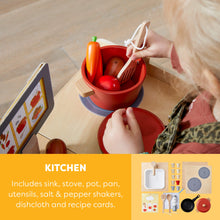 Load image into Gallery viewer, Child playing with toy kitchen set on a wooden surface
