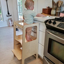 Load image into Gallery viewer, Child standing on a wooden step stool in a kitchen
