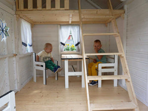 Children playing in a wooden playhouse , sitting on the children's furniture behind the table, on the picture ladder to the loft by WholeWoodPalyhouses