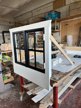 Load image into Gallery viewer, Two Side Shop window frame with black trim for the Arctic Auk playhouse, placed on a workbench in a workshop environment by WholeWoodPlayhouses
