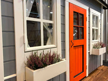Load image into Gallery viewer, Playhouse Kids Cave with a bright orange door and window flower boxes filled with heathers by WholeWoodPlayhouses
