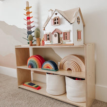 Load image into Gallery viewer, Wooden toy shelf with a dollhouse, rainbow toys, and storage baskets in a child's room.
