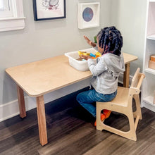 Load image into Gallery viewer, Child sitting at a wooden table with toys, wearing a gray hoodie and blue jeans.
