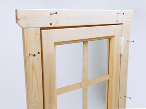Close-up of wooden playhouse door frame with glass pane and visible assembly screws