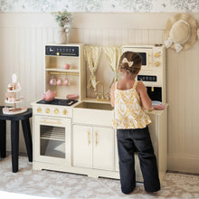 Load image into Gallery viewer, Child playing with a toy kitchen set in a room with decorative elements.
