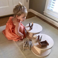 Load image into Gallery viewer, Child playing with miniature furniture and accessories on a small round table.
