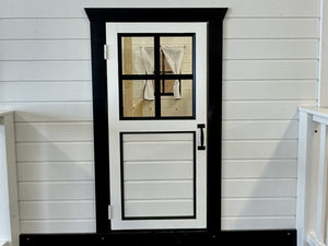 White wooden door with black frame and glass panel on a white wooden wall by WholeWoodPlayhouses