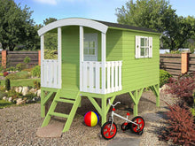 Load image into Gallery viewer, Green Kids Playhouse DIY Kit Little Bungalow in the backyard with a bike next to it by WholeWoodPlayhouses
