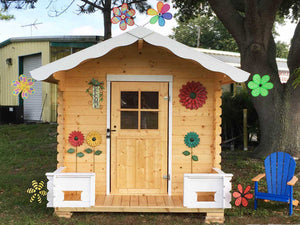 Front outside view of assembled wooden kids playhouse DIY Kit Little Cabin with decorations | outdoor playhouse DIY kit by WholeWoodPlayhouses