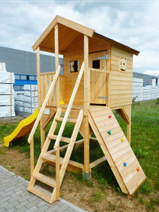 Outside of outdoor playhouse DIY kit Little Tower with a slide and climbing wall by WholeWoodPlayhouses