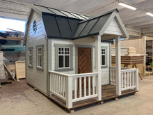 Load image into Gallery viewer, Outside of Kids Playhouse Grand Farmhouse black and white Outdoor Playhouse With Terrace And White Railings, Brown Fishbone Style Wooden Door by WholeWoodPlayhouses
