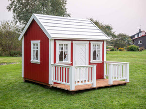 Red Outdoor Kids Playhouse Nordic Nario With White Metal Roof, Pressure Treated Brown Wooden Terrace And White Wooden Railing On Green Lawn by WholeWoodPlayhouses