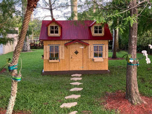 Outside Assembled Wooden Farmhouse Style Kids Outdoor Playhouse DIY Kit Little Farmhouse With Natural color Walls and red roof with small windows in the Backyard by WholeWoodPlayhouses