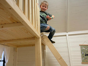 Boy Playing Inside on the Loft in Wooden Playhouse Arctic Auk by WholeWoodPlayhouses
