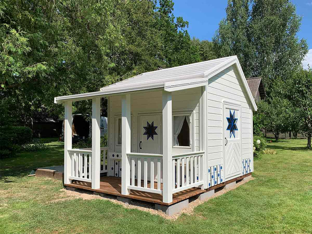 White and blue Kids Playhouse Countryside with covered porch on green lawn by WholeWoodPlayhouses