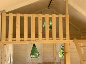 Inside of a outdoor playhouse Countryside with a wooden loft , a round top window and ladder to loft by WholeWoodPlayhouses