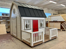 Load image into Gallery viewer, Kids OutDoor Playhouse Farmhouse Left Side View, With White Walls and Black Metal Roof, Terrace and White Railings, Beige Wall Trim, Dark Red Fishbone Style Wooden Dutch Door, One Full Size Adult Door, Four Opening and One Round Windo in WholeWoodPlayhouses Shop

