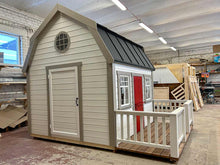 Load image into Gallery viewer, Kids OutDoor Playhouse Farmhouse Left Side View, With White Walls and Black Metal Roof, Terrace and White Railings, Beige Wall Trim, Dark Red Fishbone Style Wooden Dutch Door, One Full Size Adult Door, Two Front Side Opening and One Round Window in WholeWoodPlayhouses Shop
