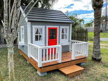 Load image into Gallery viewer, Kids Outdoor Wooden Playhouse Kids Cave With  Metal Roof, wooden terrace and Red Half Glass Door in the backyard By WholeWoodPlayhouses
