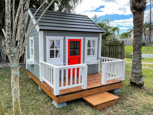 Kids Outdoor Wooden Playhouse Kids Cave With  Metal Roof, wooden terrace and Red Half Glass Door in the backyard By WholeWoodPlayhouses