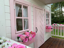 Load image into Gallery viewer, 2- story Custom Wooden Playhouse Closeup of front windows and pink flower boxes with pink flowers and fishbone door by WholeWoodPlayhouses
